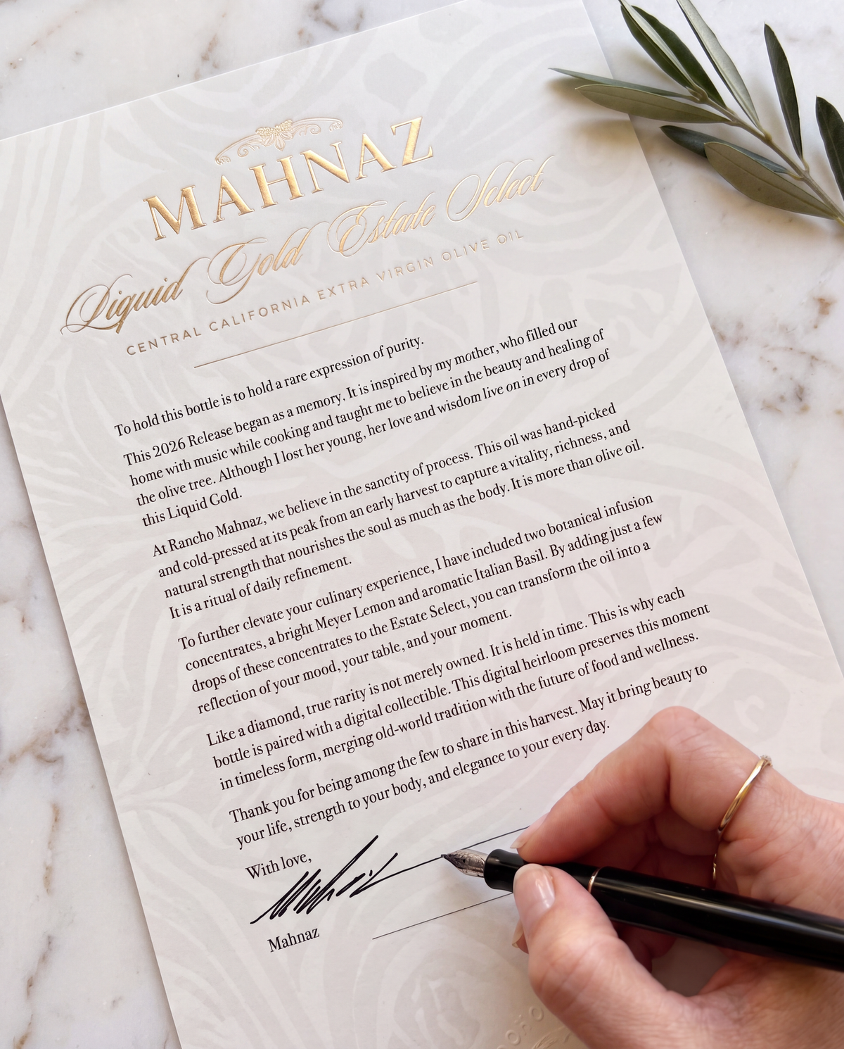 Mahnaz signing a numbered Liquid Gold certificate of authenticity