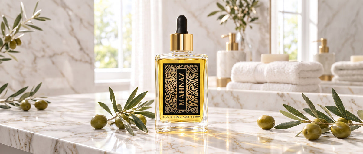 Mahnaz Liquid Gold Face Serum, 50 ml, on a white marble bathroom counter with olive branches