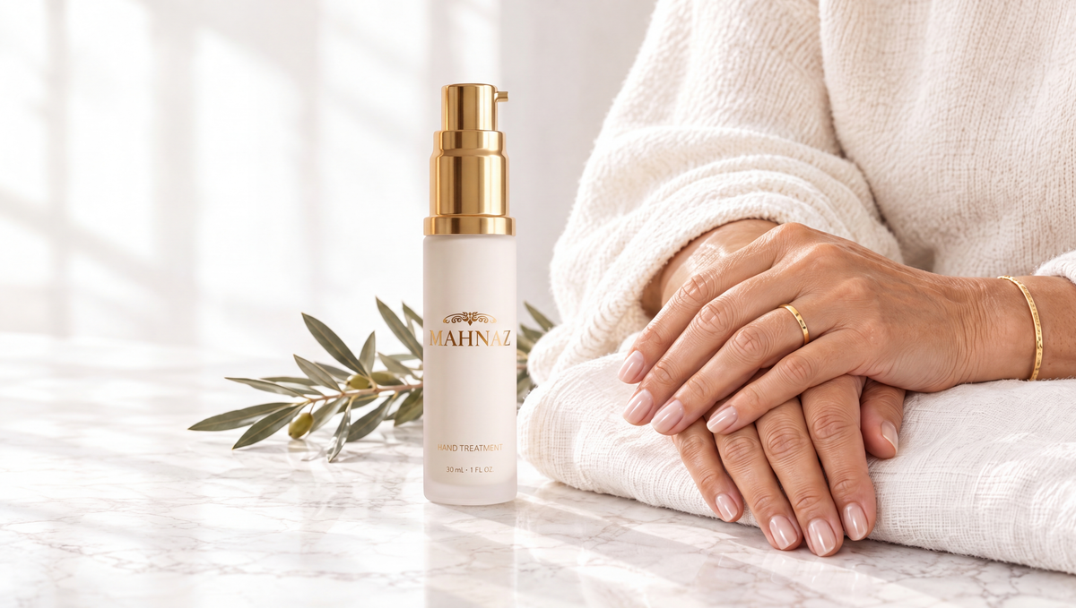 A woman's hands resting on white linen beside the Hand Treatment bottle