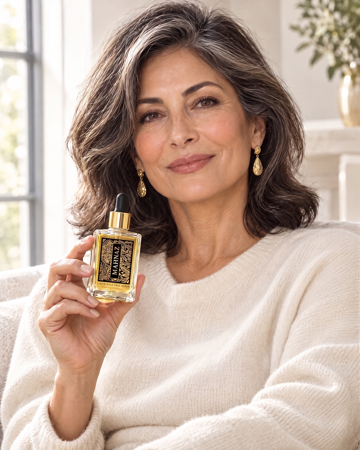 A woman by a window holding the Liquid Gold Face Serum
